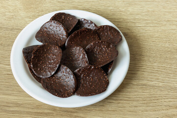 Dark chocolate chips in a plate on the table