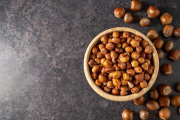 Hazelnuts in a wooden bowl, top view, copy space