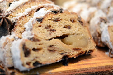 A food shot of a specialty Christmas cake sliced and drizzled with white sugar powder.