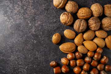 Mix of nuts on dark background. Almonds, hazelnuts, walnuts. Top view. 