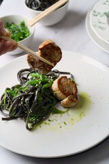 polędwiczka wieprzowa z czarnym makaronem i zielonymi glonami © Fotosylwester