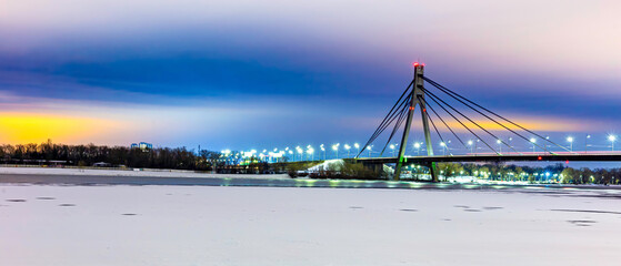 Night view of the Pivnichnyi Bridge ex Moskovsky bridge on the Dnieper river in Kiev, Ukraine, at evening during the blue hour. high resolution panorama