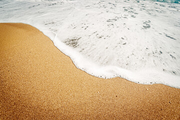 Wave and sandy beach.