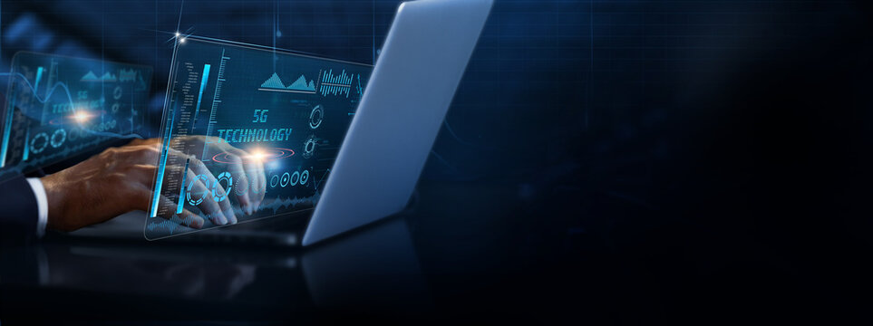 5G Technology: Businessman using laptop and analyzing 5G technology information on futuristic virtual interface screen, high-speed connectivity, low latency, network slicing, IoT integration.
