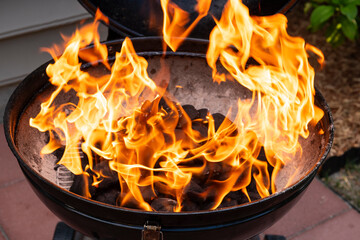 A close-up view of a charcoal grill with vibrant flames, perfect for barbecue themes or outdoor cooking concepts.