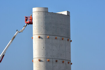 Operai su Piattaforma a Braccio su Struttura in Cemento