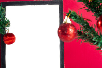 White empty frame with Christmas decorations on vibrant red background