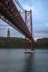 Fototapeta premium Panoramic Exposure done from a Cruise ship, while arriving at Lisbon at sunrise, of the 25th April Bridge and Tagus River, with Lisbon on the left bank and the Sanctuary of Christ the King, Lisbon,Por