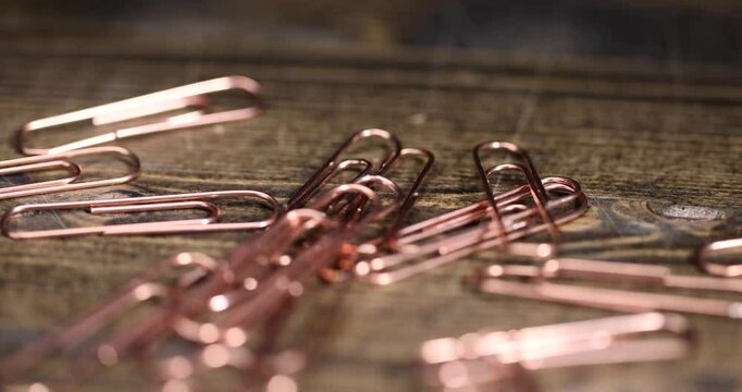 copper paper clips for the systematization of documents and paper, large-size copper paper clips close-up on the board