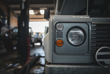 Headlight of an old classic car in a garage after restoration.