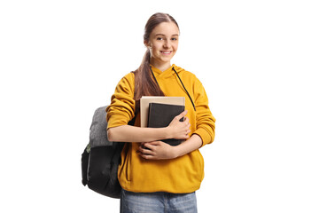 Female teenage student holding books and smiling