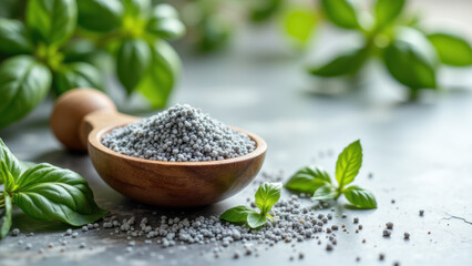 Celtic sea salt with a mortar and pestle, basil leaves, and a wooden bowl on a gray countertop.