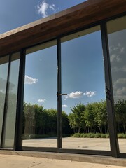 Fototapeta premium Large glass door reflecting the sun and sky.