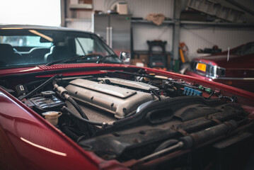 Inline six engine of a classic, luxury car exposed as bonnet is removed.