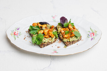 Toast with shrimp, guacamole and herbs.