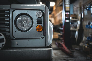 Headlight of an old classic car in a garage after restoration.