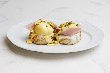 Eggs Benedict with stracciatella, pistachios and sauce.