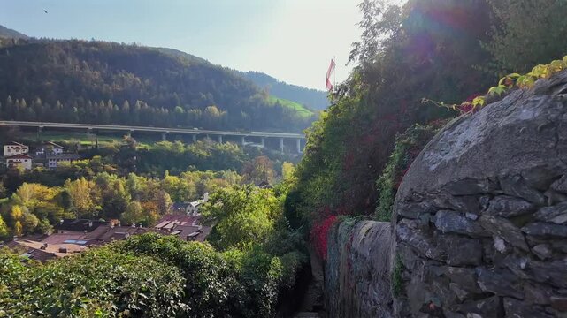 Beautiful footage of Klausen in South Tyrol, Italy, showcasing autumn colors, mountain slopes, and the iconic Brenner Autobahn bridge crossing the valley. A perfect blend of nature and engineering.