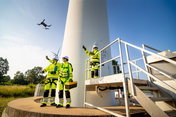 A group of workers in high-visibility gear joyfully high-fives each other after completing their...