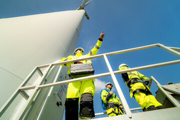 A group of  workers in high-visibility gear joyfully high-fives each other after completing their...