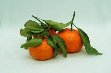 Fresh tangerines with leaves on a colored background, fruits, vitamins.