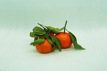 Fresh tangerines with leaves on a colored background, fruits, vitamins.