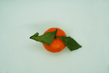 Fresh tangerines with leaves on a colored background, fruits, vitamins.