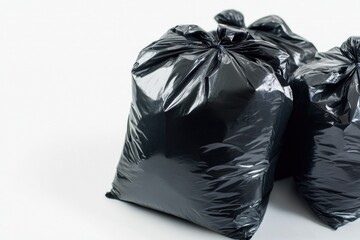 Two black trash bags placed on a clean white surface