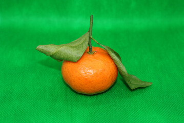 Fresh tangerines with leaves on a colored background, fruits, vitamins.