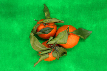 Fresh tangerines with leaves on a colored background, fruits, vitamins.