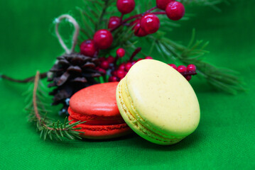 A spruce branch with a pine cone and multi-colored macaroons on a beautiful background, holiday, Christmas.