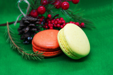 A spruce branch with a pine cone and multi-colored macaroons on a beautiful background, holiday, Christmas.