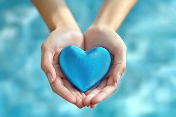Obraz premium A person holds a blue heart in their hands, a symbol of love and affection