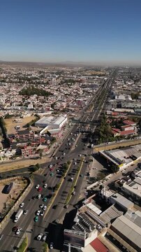 vertical drone video of Mexican Durango city main highways with lots cars moving in a sunny bright day 