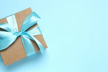 Beautiful gift box tied with bow on color background 