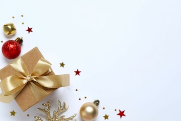 Beautiful gift box tied with bow and Christmas decorations on white background 