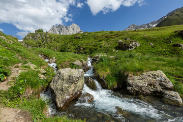 Hiking trail to Chaukhi mount from the village of Juta. Beautiful waterfall under Chaukhi. Chaukhistskhali river. Breathtaking landscape.