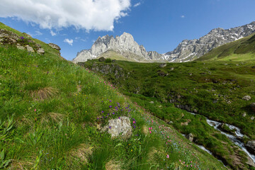 Naklejka premium Hiking trail to Chaukhi mount from the village of Juta. Beautiful waterfall under Chaukhi. Chaukhistskhali river. Breathtaking landscape.