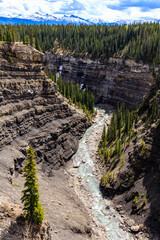 A river runs through a canyon with trees on either side