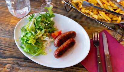 Traditional French savoy sausage with arugula on a plate