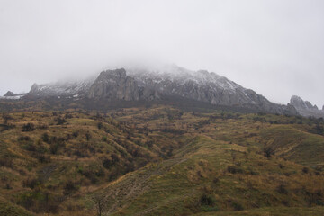 View of Mount Suryu-Kaya in Crimea on an autumn foggy day. Part of the mountain is hidden by a cloud.