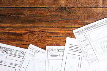 Developing UI design. Sketches of website wireframes on wooden table, top view