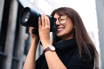 Professional photographer taking picture with camera outdoors