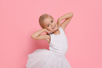 Little girl pretending to be ballerina on pink background. Dreaming of future profession