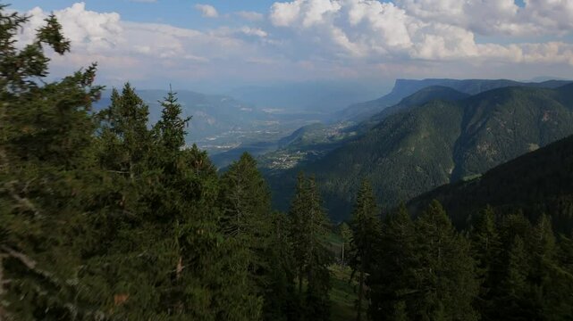 Drone footage of dense forest on Vigiljoch with expansive views over the Merano Valley, South Tyrol, Italy, capturing rugged mountain landscapes and lush alpine scenery.