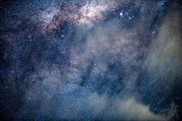 Fototapeta premium Close Up: Exploring the Night Sky and Milky Way with clouds drifting past