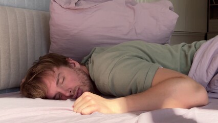 young man sleeping in bed in bedroom in the morning