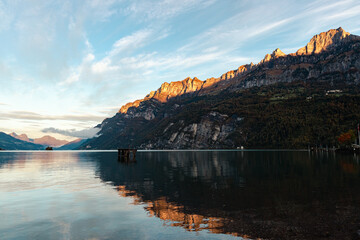 a picturesque mountain landscape with a crystal clear lake reflecting majestic rocks and green...