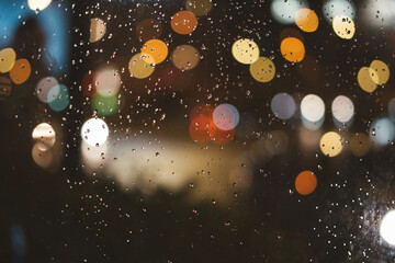 blur colorful lights with raindrops on glass