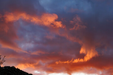 Vibrant sunset colors streak across the sky with deep blues and fiery oranges in a tranquil evening landscape
